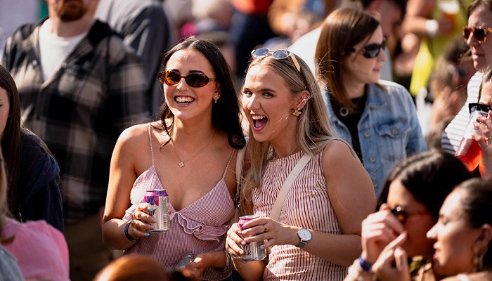 2 girls laughing in the middle of the croud