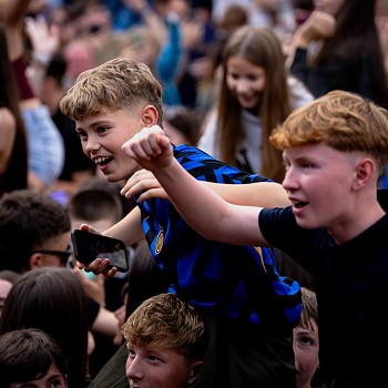 2 fachgen ar ysgwydda pobl yng nghanol y dorf
